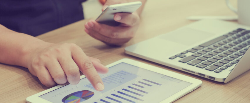 Person on phone and tablet looking at analytics