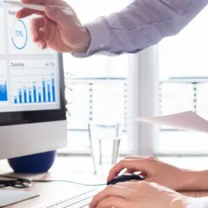 Two people discussing digital trends on desktop computer