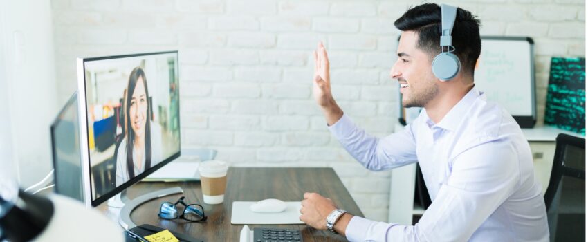 man waving to colleague on video conference