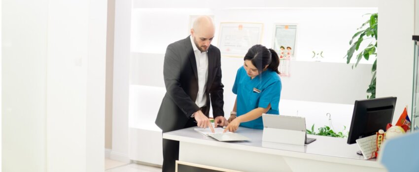 dental assistant making an appointment with client in dental clinic