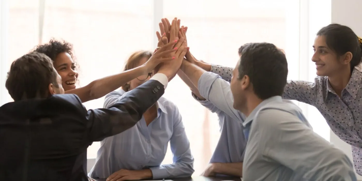excited multi racial businesspeople celebrating corporate success