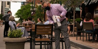 Man cleaning tables in Larimer Square, Denver