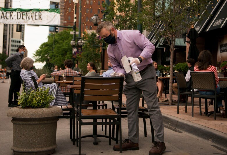Man cleaning tables in Larimer Square, Denver