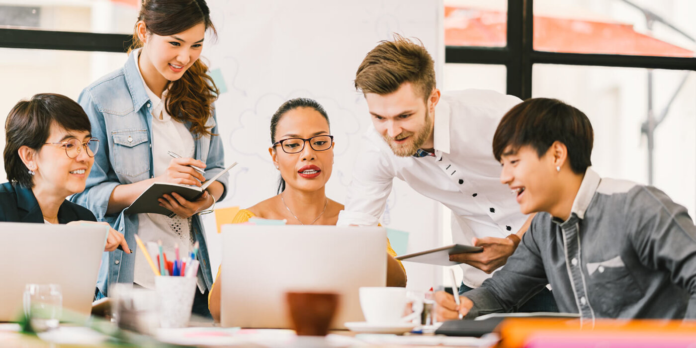 Company Employees gathering around laptop