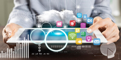 Icons of marketing channels as well as transparent graphs are overlaid on an image of a person holding a tablet, indicating marketing analysis.