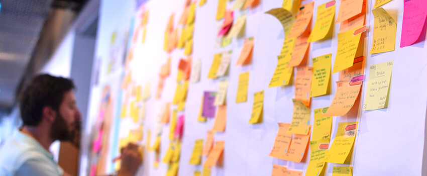 An agile software developer is updating Kanban board