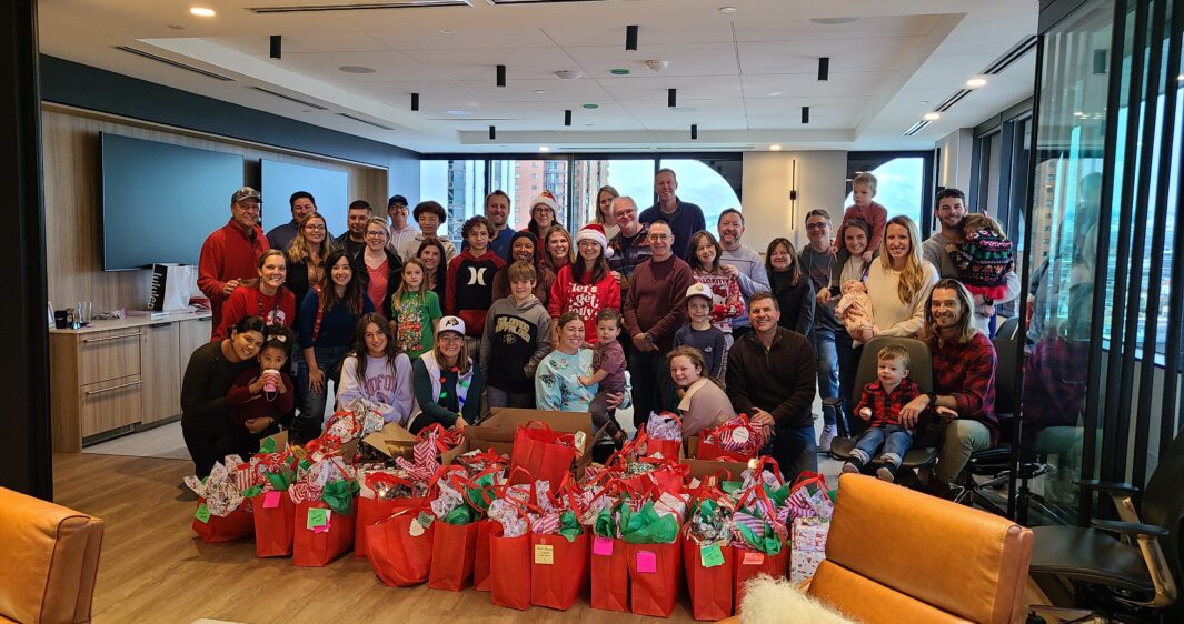 RevGen volunteers pose after wrapping donated holiday gifts for 59 children from Valverde Elementary