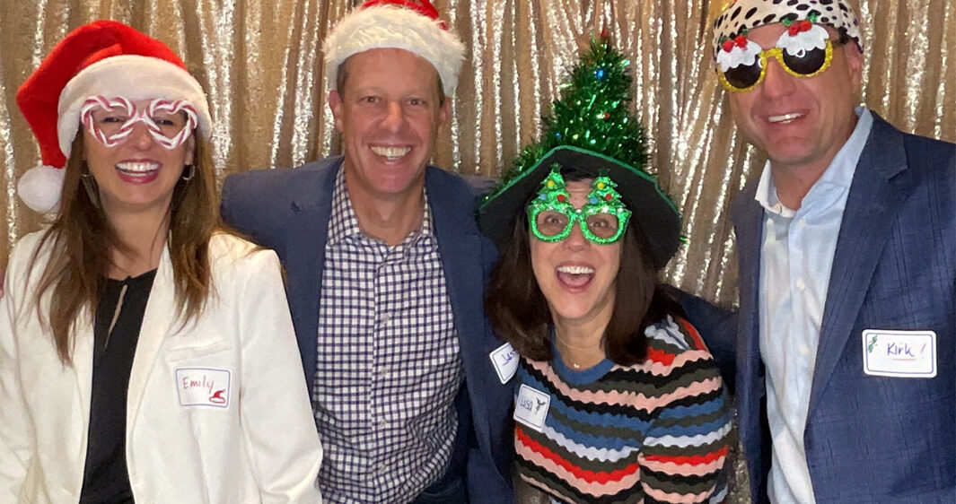 Emily Sims, Jason Hansen, Lisa Walvoord, and Kirk Mielenz pose with props during the RevGen Holiday Party