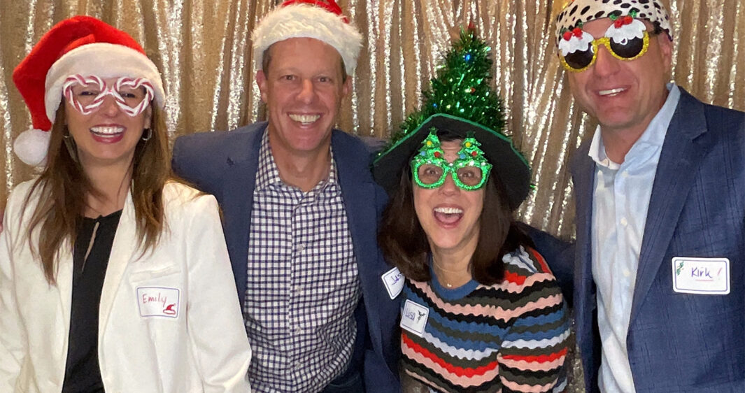 Emily Sims, Jason Hansen, Lisa Walvoord, and Kirk Mielenz pose with props during the RevGen Holiday Party