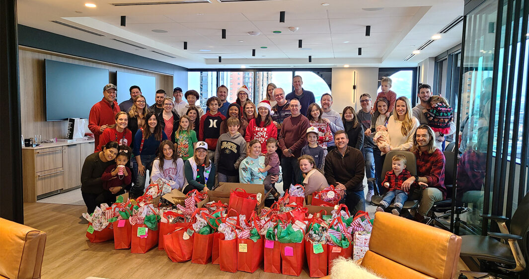 RevGeners and their families pose after wrapping their donated gifts for 59 children and their families at our Holiday Volunteer Event.