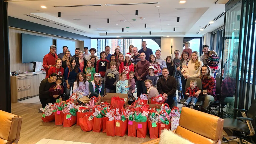 RevGeners and their families pose after wrapping their donated gifts for 59 children and their families at our Holiday Volunteer Event.
