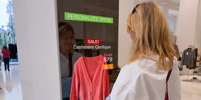 A woman in a shopping mall stops at a screen to view her AI-powered personalized offers.