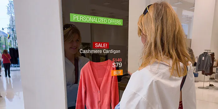 A woman in a shopping mall stops at a screen to view her AI-powered personalized offers.