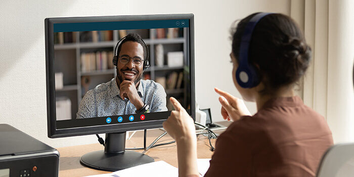 A woman talks with her hands during a remote coaching session.