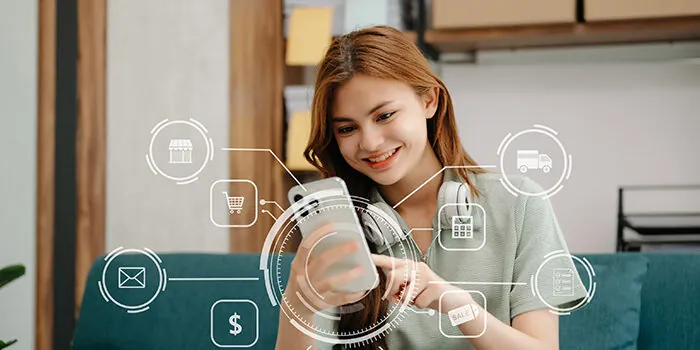 A woman smiles down at her phone. Holograms of icons describing touchpoints along the customer journey spiral out from the screen.