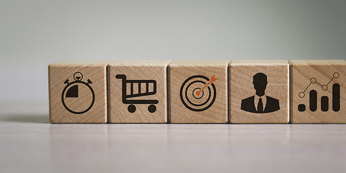 Wooden blocks with various icons depicting the customer journey and customer experience metrics