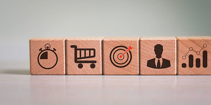 Wooden blocks with various icons depicting the customer journey and customer experience metrics