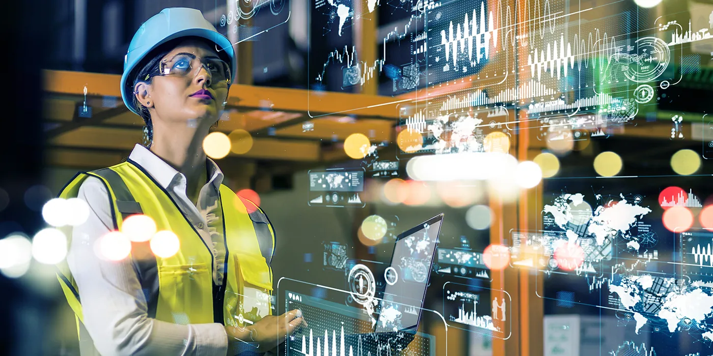 A female construction project manager looks at holographic charts projected over a construction site