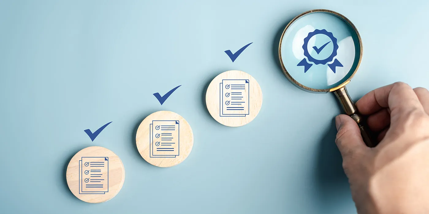 a magnifying glass rests over an award icon, while three completed checklist icons lead up to it