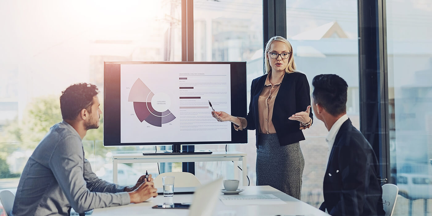 Businesswoman presenting graphs to colleagues in a bright office setting