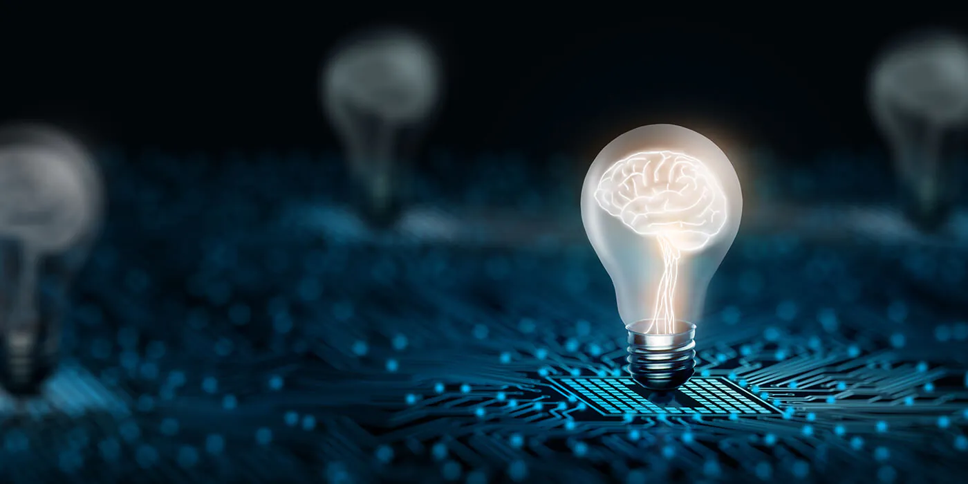 CGI image of several lightbulbs hovering over a circuit board. The lightbulb in the foreground has a lit up brain inside of it.